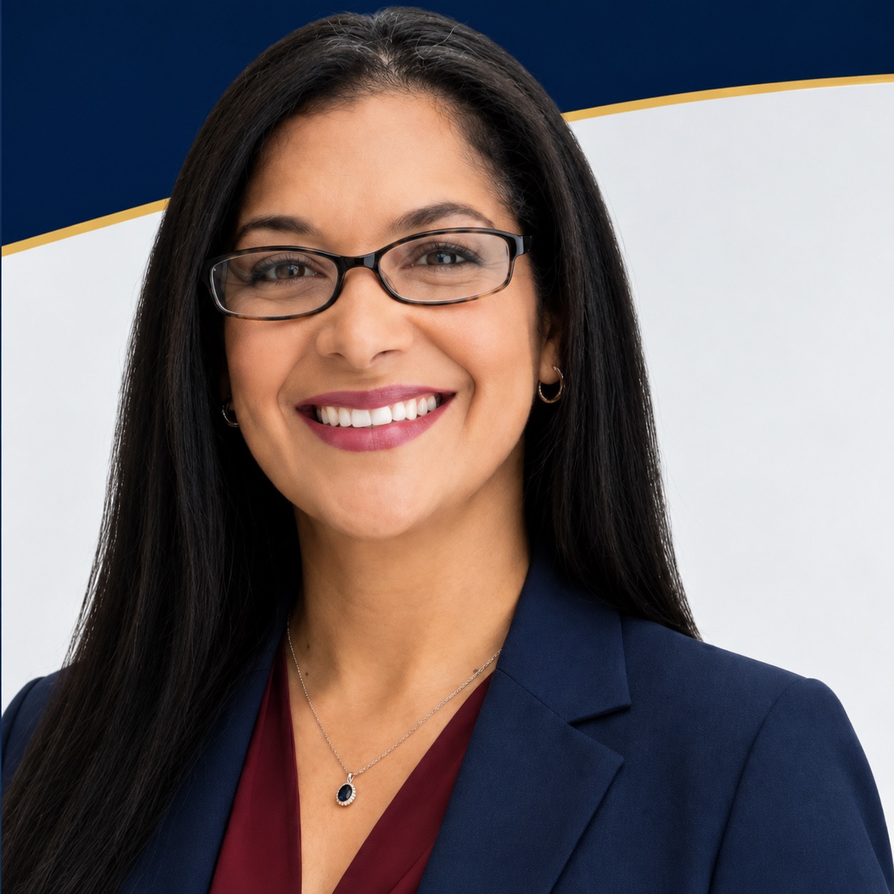 Mia Perez-Arroyo, attorney at law, wearing a navy blazer and glasses